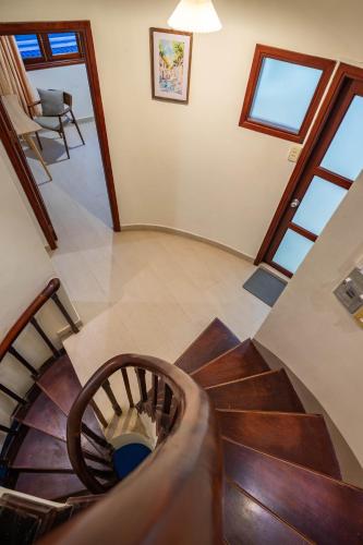 a spiral staircase in a home with wooden floors and windows at Thao Dien Coliving in Ho Chi Minh City