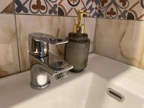 a bathroom sink with a faucet and a soap dispenser at LEO Apartment in Belgrade