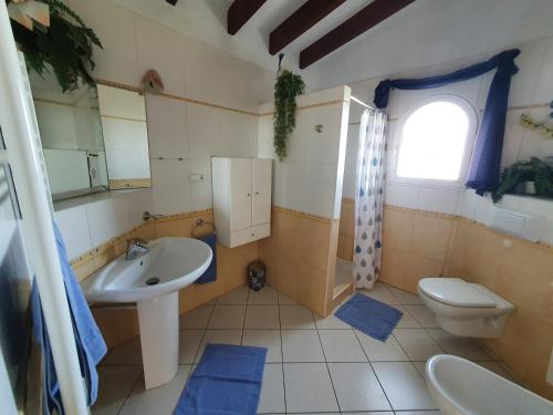 a bathroom with a sink and a toilet and a window at Ma-Nita in Ráfol de Almunia