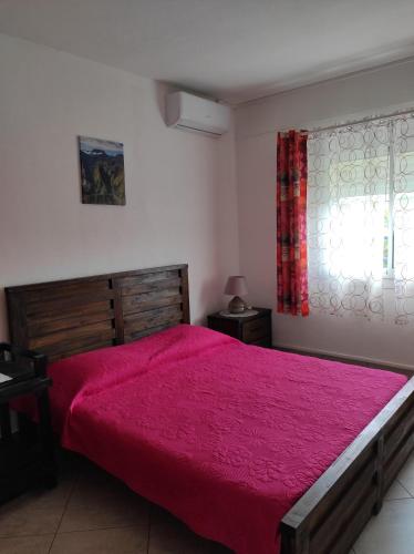 una camera da letto con un letto grande con un copriletto rosso di Combava a Saint-Pierre