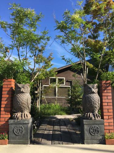 two stone owl statues in front of a house at 長崎の丘に浮かぶ天空テラス Villa 森の魔女 ,Villa Forest Witch in Nagasaki
