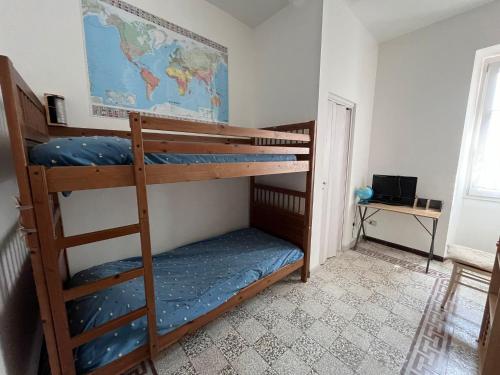 two bunk beds in a room with a desk at Trilocale a due passi dal lago La Vattutella in Marta