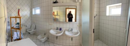 a bathroom with three sinks and two toilets at Ferienwohnung Hainspitz Longstay in Hainspitz