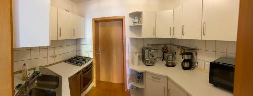 a kitchen with white cabinets and white appliances at Ferienwohnung Hainspitz Longstay in Hainspitz