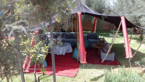 a gazebo with a couch and a table at Villa Palmengarten Meknès bei Fes in Meknès