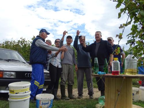 a group of people standing around a table with their hands up at Farm Stay Frank Ozmec Wine and Glamping estate in Ljutomer
