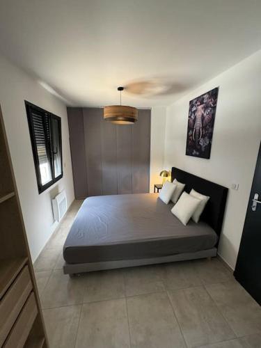 une chambre avec un grand lit dans une pièce dans l'établissement Appartement neuf centre du village, à Le Puy-Sainte-Réparade