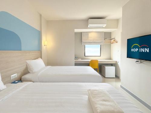 a hotel room with two beds and a flat screen tv at HOP INN Prachuap Khiri Khan in Prachuap Khiri Khan