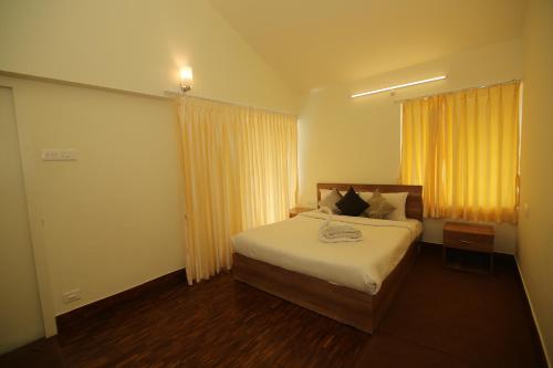 una camera con letto e finestra con tende gialle di Tiger Hill Homestay a Ooty