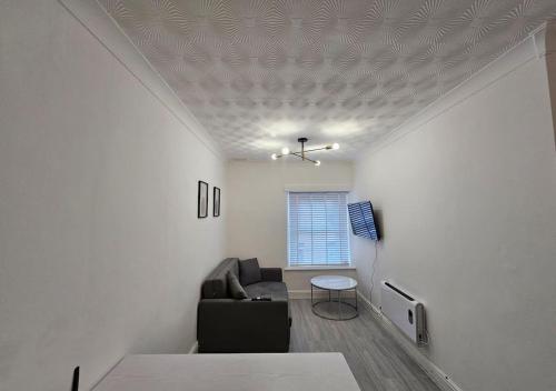 a living room with a couch and a table at Modern & Stylish 1 bedroom flat in Bridgend town in Bridgend