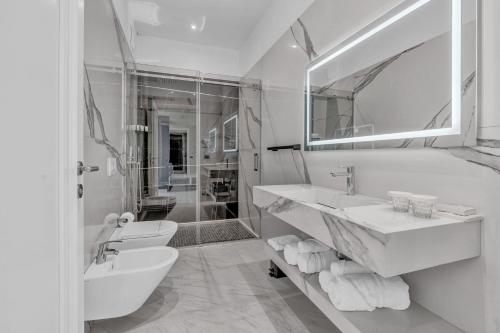 a white bathroom with a sink and a mirror at Hotel Plaza Berat in Berat