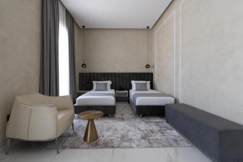 a hotel room with two beds and a couch at Hotel Plaza Berat in Berat