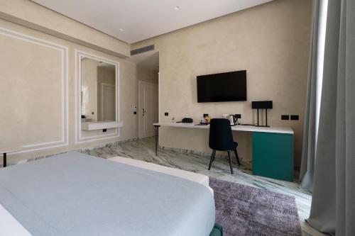 a bedroom with a bed and a desk with a television at Hotel Plaza Berat in Berat