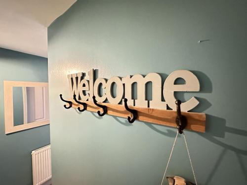 a sign that says welcome hanging on a wall at Starfish Shack - Part of the The Bay Filey Holiday Village with pool, gym and direct beach access, pub, restaurant, tennis and meadows walks in Filey