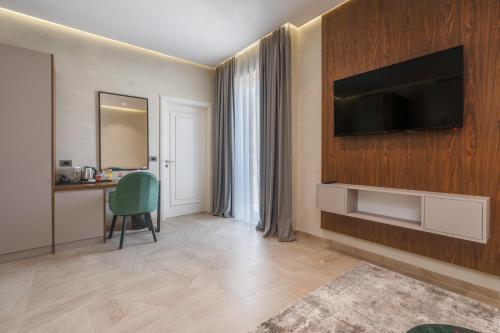 a living room with a television on a wall at Hotel Plaza Berat in Berat