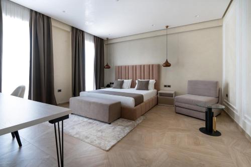 a bedroom with a bed and a couch and a chair at Hotel Plaza Berat in Berat