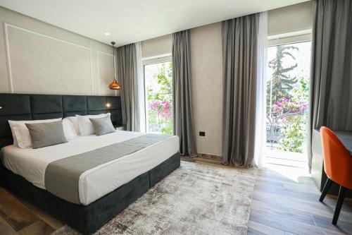 a bedroom with a bed and a large window at Hotel Plaza Berat in Berat
