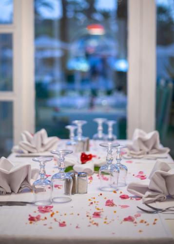 a table with glasses and napkins and flowers on it at Hotel Marhaba Beach in Sousse