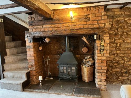 a fireplace in a stone wall with a stove at Magnolia Cottage in Wellington