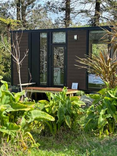a modern cabin in the woods with plants at Golden Valley Retreat by Tiny Away in Waihi