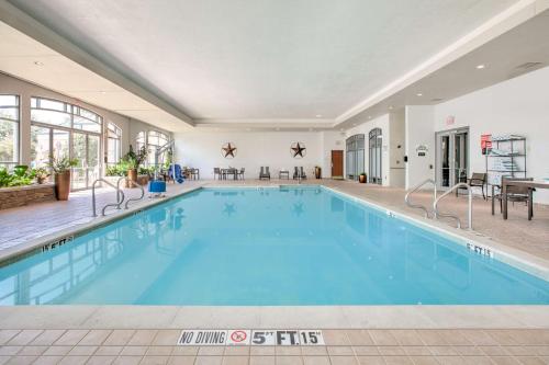 a large swimming pool with blue water in a building at Embassy Suites Dallas - DFW Airport North in Grapevine