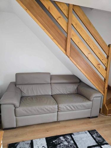 a couch in a living room under a stairs at 3 bedroom detached house centre of Whitchurch in Whitchurch