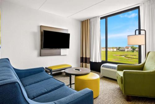 a hotel room with a couch and chairs and a tv at Comfort Inn Gold Coast in Ocean City