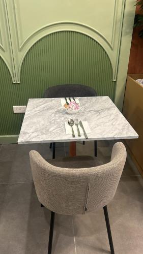a white table with two chairs and a table and a table and chairsuggest at King Charles Hotel in Valletta