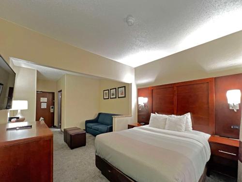 a hotel room with a bed and a blue chair at Quality Inn & Suites Green Bay - Ashwaubenon in Green Bay