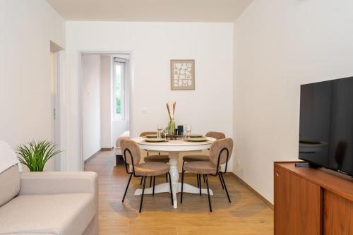 un salon avec une table et des chaises dans l'établissement Rooftop - Villa Leone - Appartement à 500m plage, à La Tente-Verte