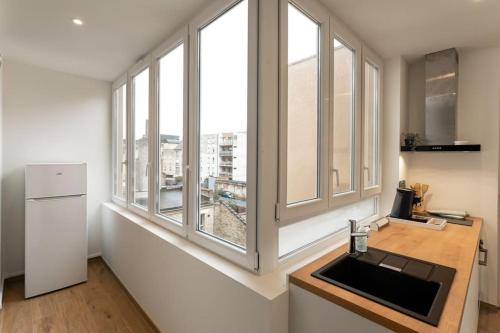 une cuisine avec un évier et une grande fenêtre dans l'établissement Rooftop - Villa Leone - Appartement à 500m plage, à La Tente-Verte