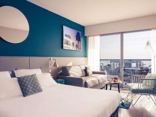 a hotel room with a bed and a couch at Mercure Villeneuve Loubet Plage in Villeneuve-Loubet