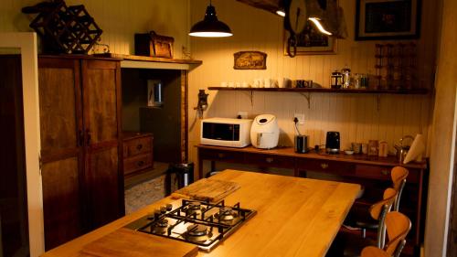 una cocina con estufa y mesa de madera en Milkwood Cottage - Seaview Serenity, en Sedgefield