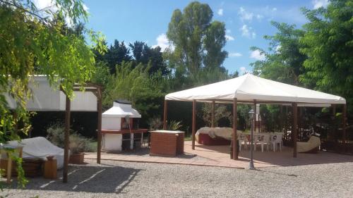 カンピーリア・マリッティマにあるCasale Acquavivaのパティオにベッドとテーブルが置かれた白いテント