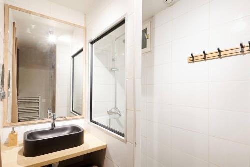 a bathroom with a black sink and a mirror at Le Flourens by Paul Riquet 1609 Residences in Béziers