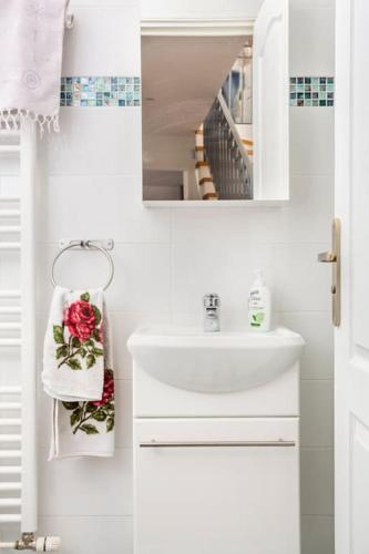 une salle de bain blanche avec un lavabo et un miroir dans l'établissement Cosy House with Paris Metro Direct Champs Elysées Eiffel Montmartre, à Saint-Denis