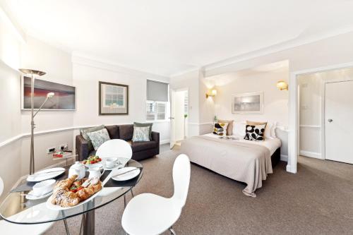 a hotel room with a bed and a table and chairs at Nell Gwynn Chelsea Accommodation in London