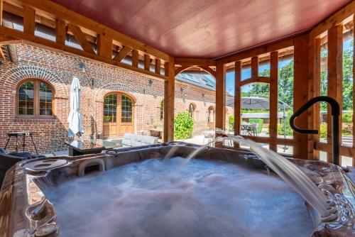 un bain à remous au milieu d'une maison dans l'établissement Piscine intérieure, SPA et Jeux open for 15 guests, à Gerponville