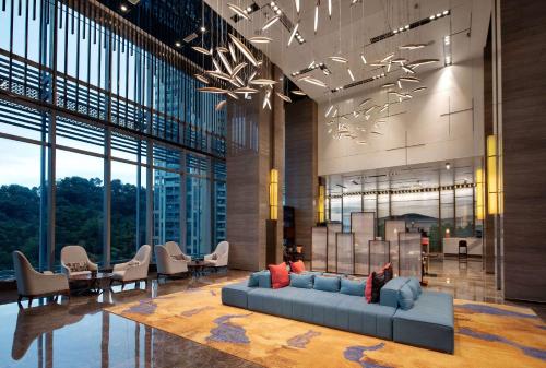 a lobby with a couch and chairs in a building at Wyndham Garden Foshan Jinshazhou in Foshan