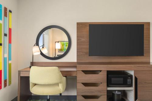 a room with a tv and a chair and a mirror at Hampton Inn & Suites Oroville in Oroville