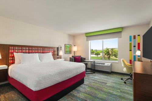a hotel room with a bed and a desk and a window at Hampton Inn & Suites Oroville in Oroville