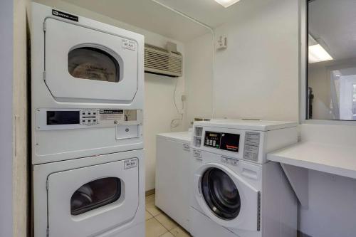 a laundry room with two washing machines and a sink at Park Inn by Radisson, Lakewood in Lakewood