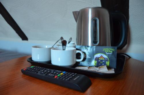 a tray with a coffee maker and cups and a remote control at Zielony Dom in Bolesławiec