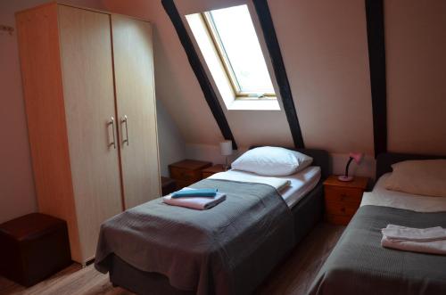a small bedroom with two beds and a window at Zielony Dom in Bolesławiec