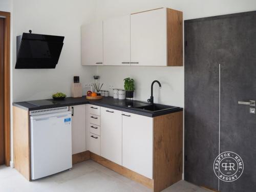una cucina con mobili bianchi e un lavandino di Przytok Golf Resort a Przylok