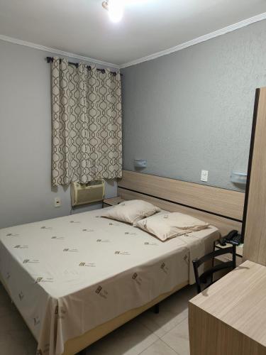 a bedroom with a large bed and a window at Hotel Brigadeiro in São Paulo