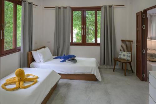 a bedroom with two beds with towels on them at Boonya Swiss Home in Chaloklum