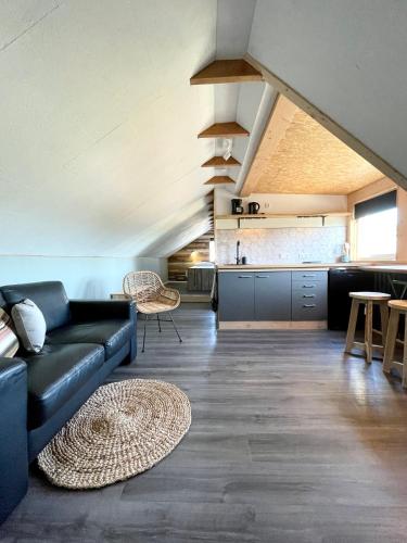 a living room with a couch and a kitchen at Het Zwaluwnest in De Vecht