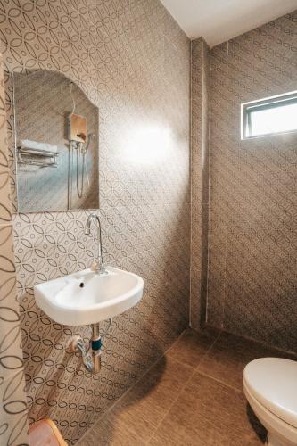 a bathroom with a sink and a toilet at Sonora's Inn, Coron in Coron