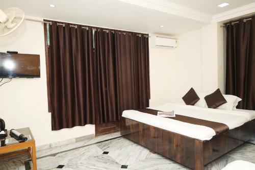 a bedroom with a bed and a large window at Hotel Sachidanand-Walkable distance from Temple in Shirdi